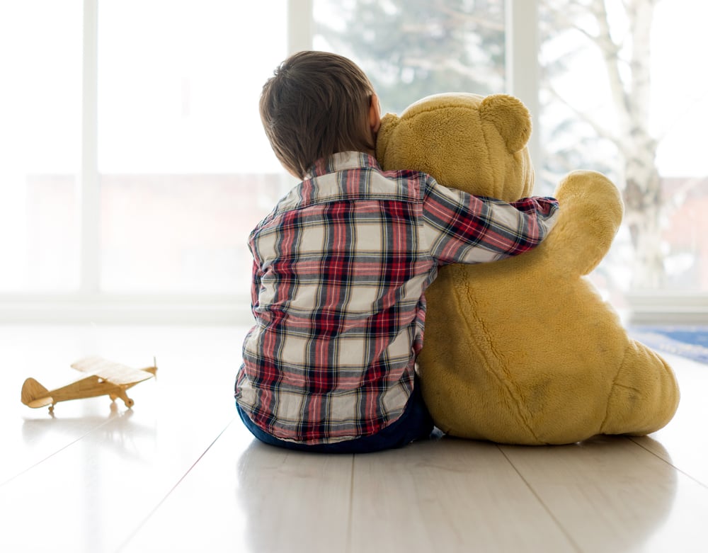 Little child sitting in living room with Teddy bear